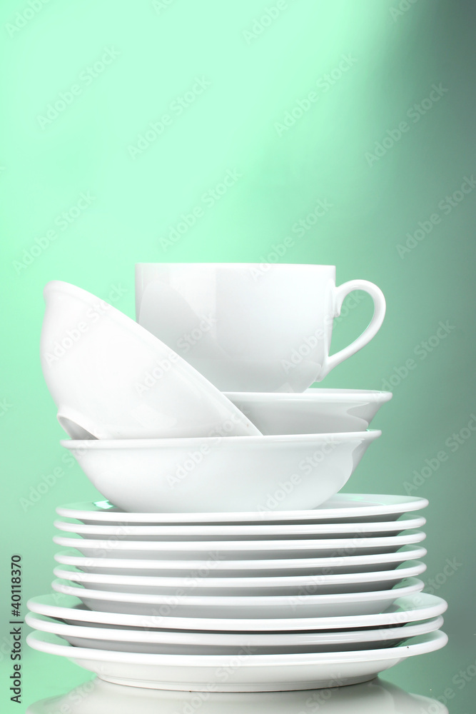 Clean plates and cup on green background Clean plates and cup on green background