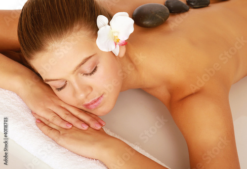 A beautiful woman relaxing in a spa center, isolated on white