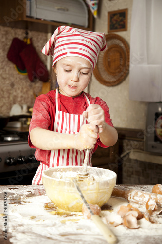 little chef in the kitchen wearing an apron and headscarf