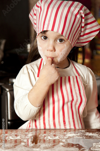 little chef in the kitchen wearing an apron and headscarf