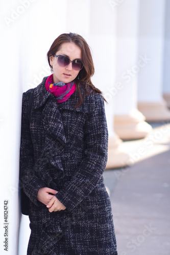Smiling woman wearing coat outdoor. Early Spring