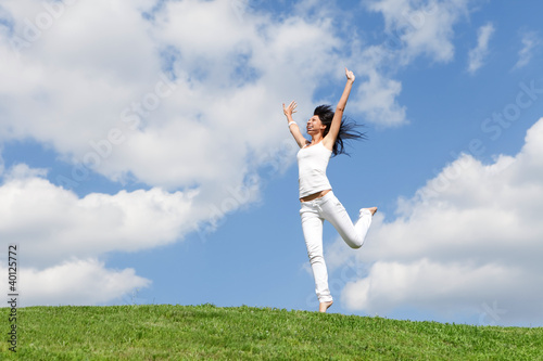 pretty young woman jumping on green grass