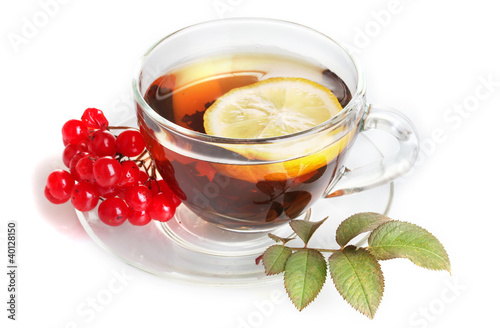 Black tea  with red viburnum and lemon in glass cup isolated
