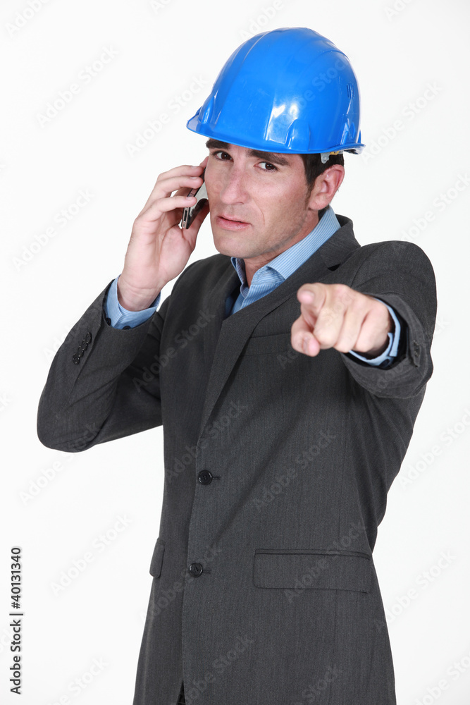 foreman on the phone pointing at something