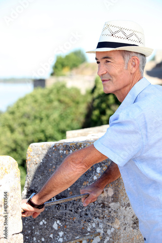 Grey-haired man visiting port town photo