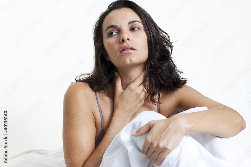 Schöne Frau mit Halsschmerzen im Bett sitzend Schöne Frau mit Halsschmerzen im Bett sitzend