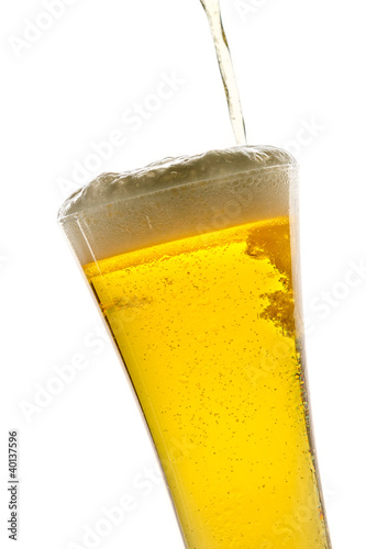 Pouring light beer into glass on white background
