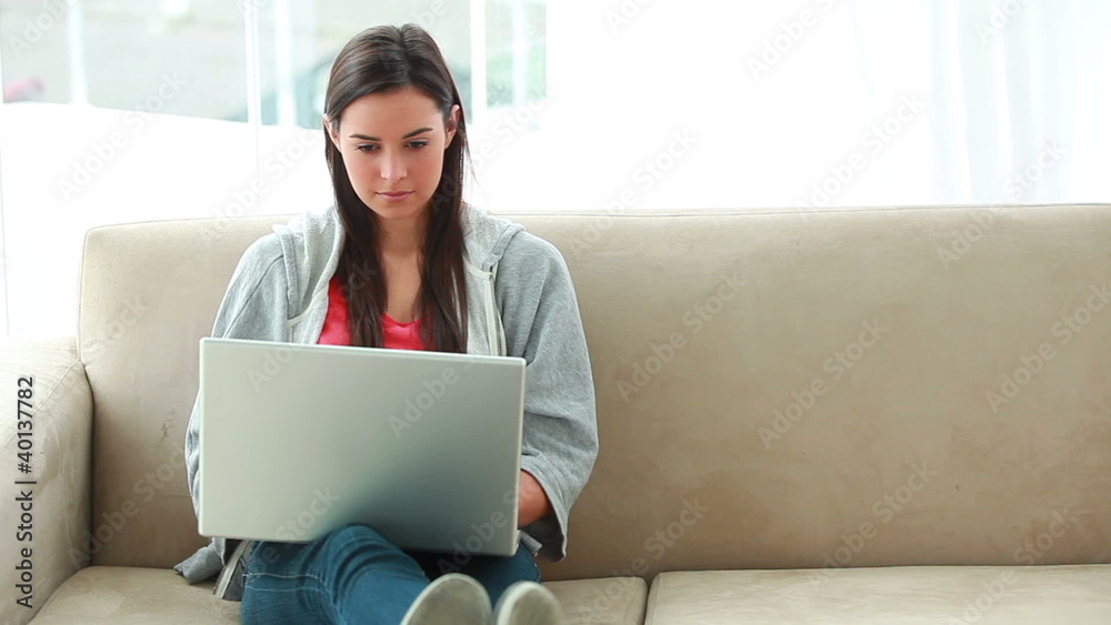 Serious brunette woman using a laptop