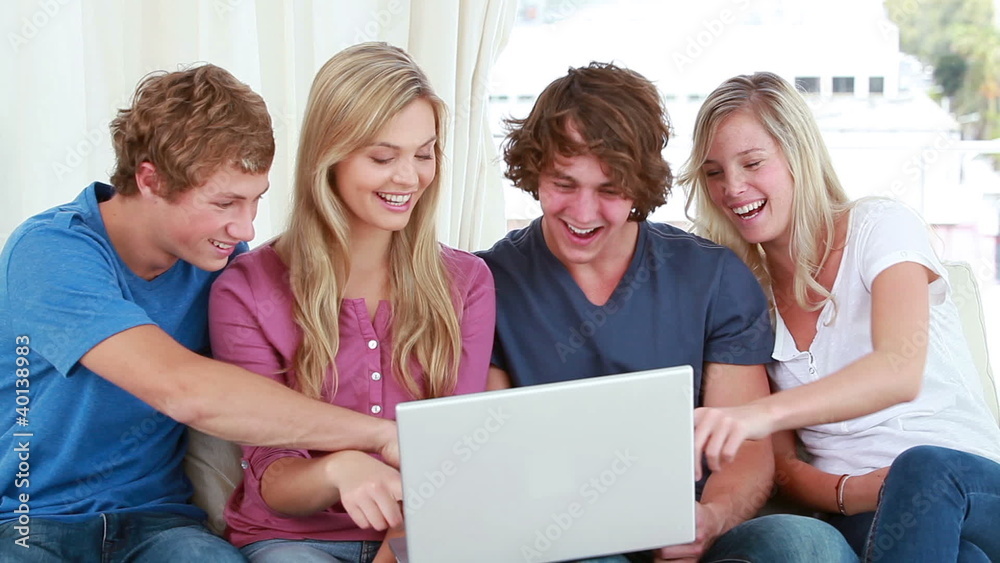 Happy friends laughing in front of a laptop Happy friends laughing in front of a laptop