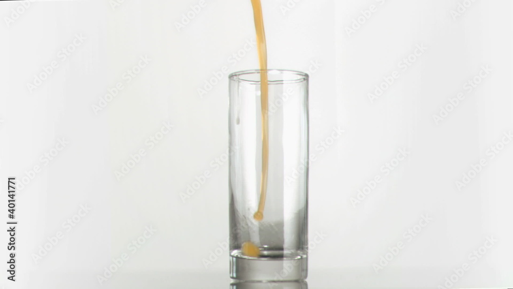 Orange juice poured in super slow motion in a glass Orange juice poured in super slow motion in a glass