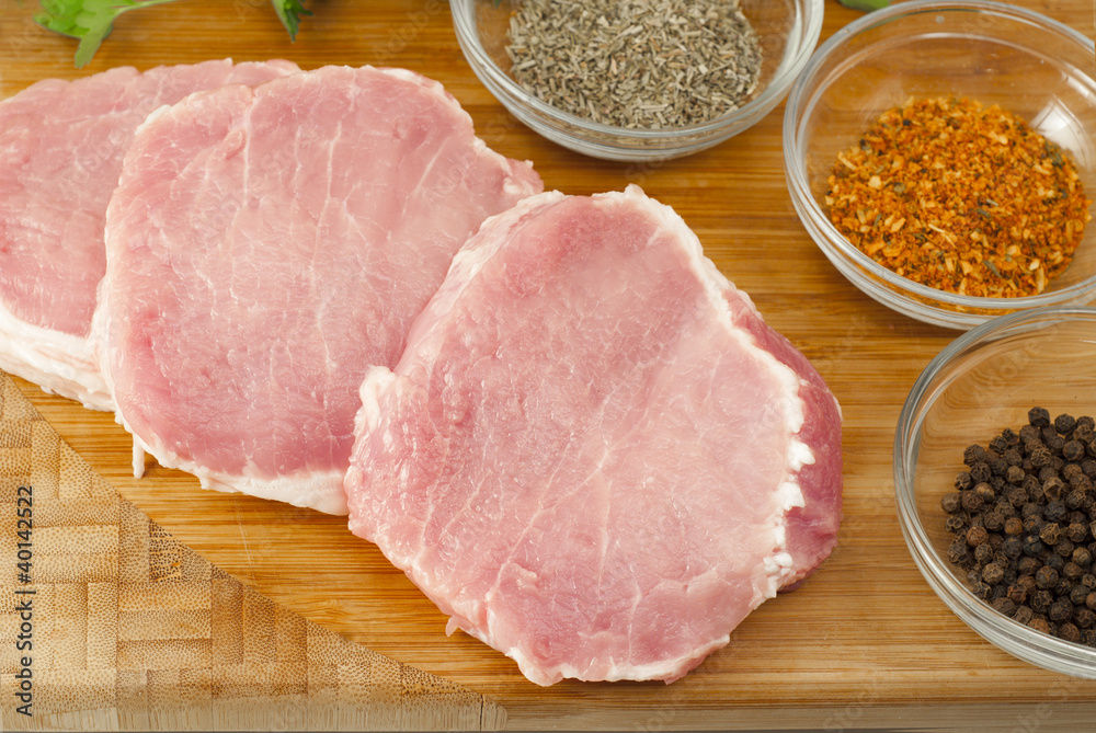 Pork chops on a cutting board with herbs Pork chops on a cutting board with herbs