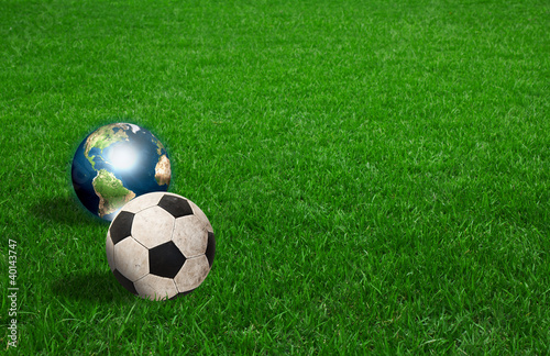 soccer ball and earth on green grass