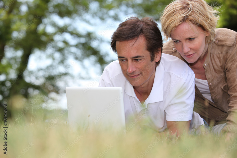 couple with laptop outdoors couple with laptop outdoors