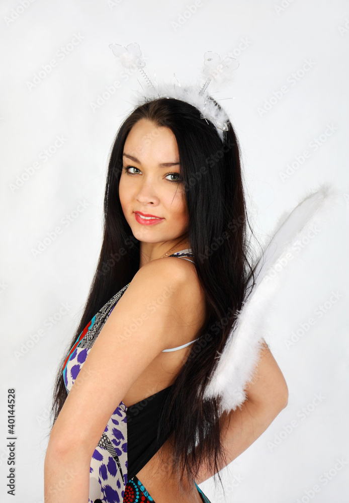 Happy beautiful girl with white wings wearing dress smiles Happy beautiful girl with white wings wearing dress smiles