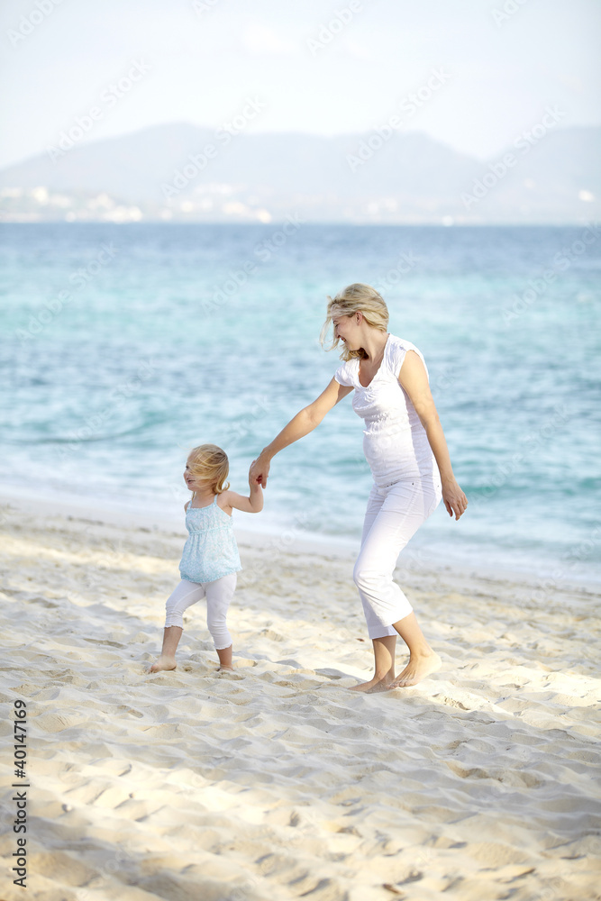 junge schwangere mutter mit ihrer tochter am strand