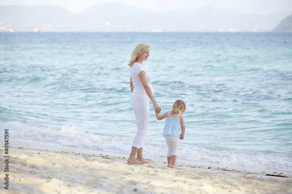 junge schwangere mutter mit ihrer tochter am strand