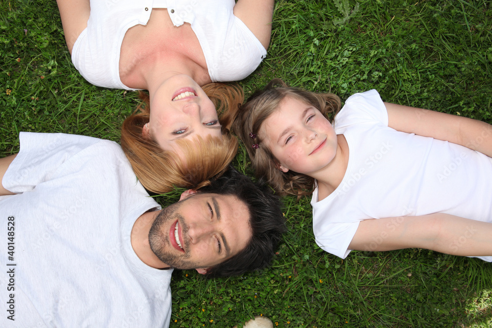 Family wearing white lying in the grass Family wearing white lying in the grass