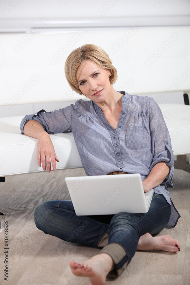woman sitting bare-footed on the floor with laptop woman sitting bare-footed on the floor with laptop