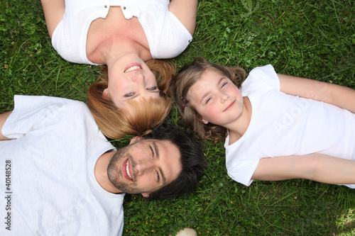 Family wearing white lying in the grass