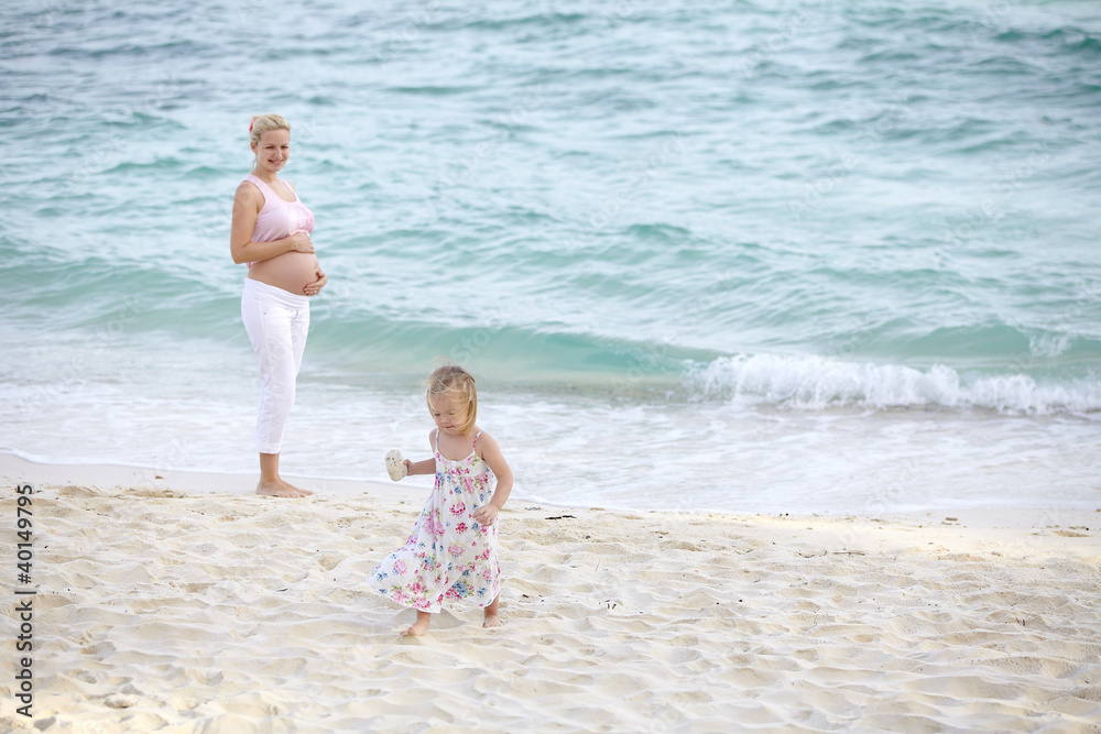 junge schwangere mutter mit ihrer tochter am strand junge schwangere mutter mit ihrer tochter am strand
