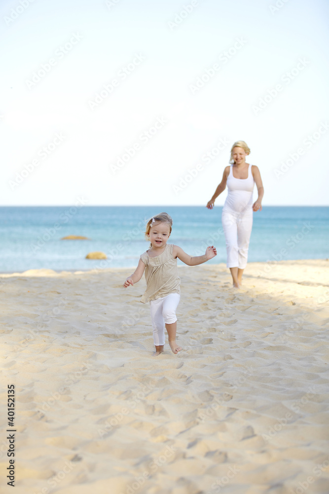 junge schwangere mutter mit ihrer tochter am strand