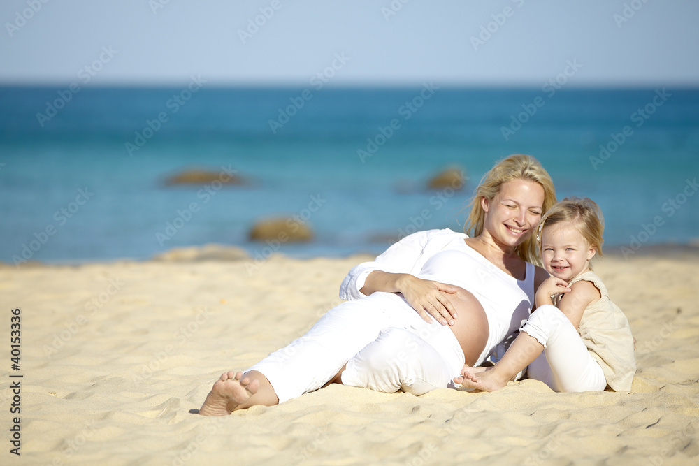 junge schwangere mutter mit ihrer tochter am strand junge schwangere mutter mit ihrer tochter am strand