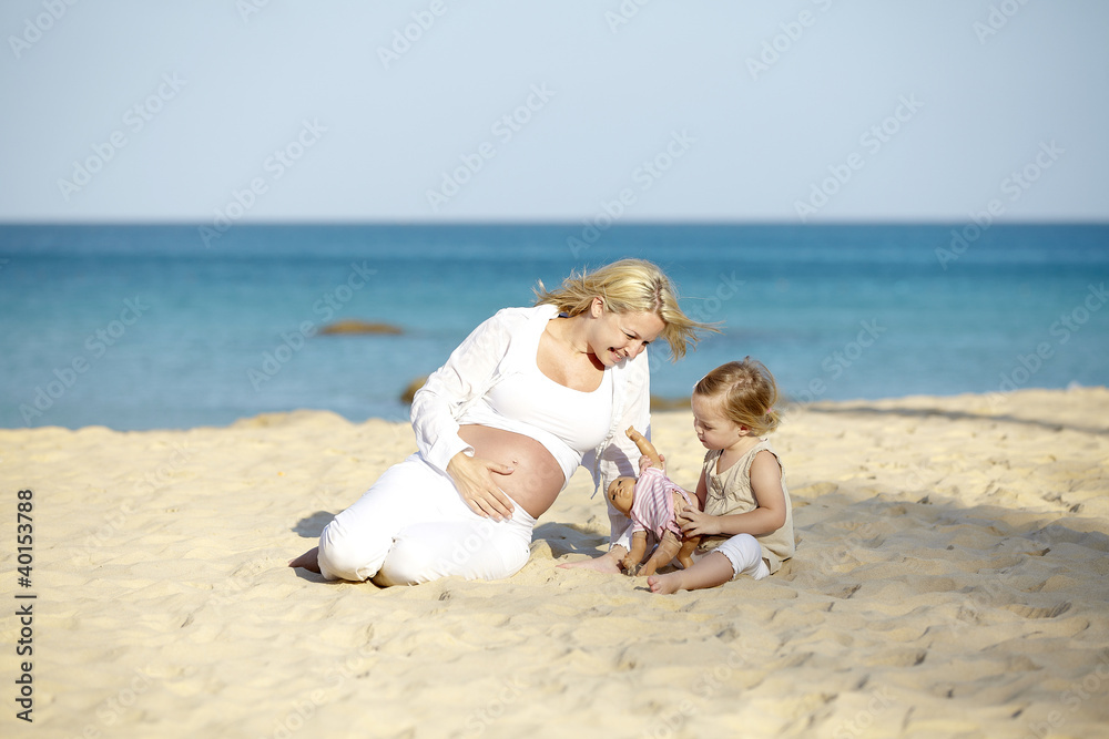 schwangere mutter spielt sand mit ihrer tochter schwangere mutter spielt sand mit ihrer tochter