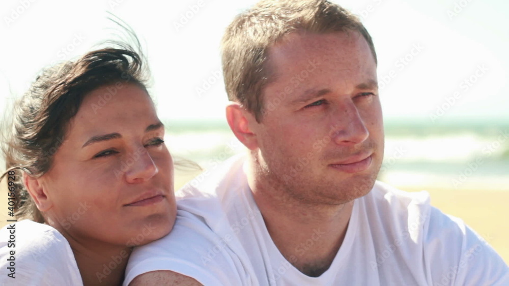 Young happy couple hugging and looking at the beach Young happy couple hugging and looking at the beach