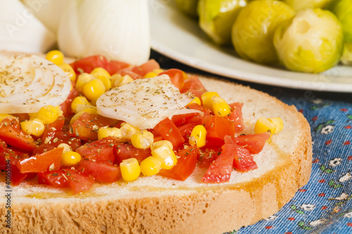 bruschetta with tomato, onion and corn on blue tablecloth