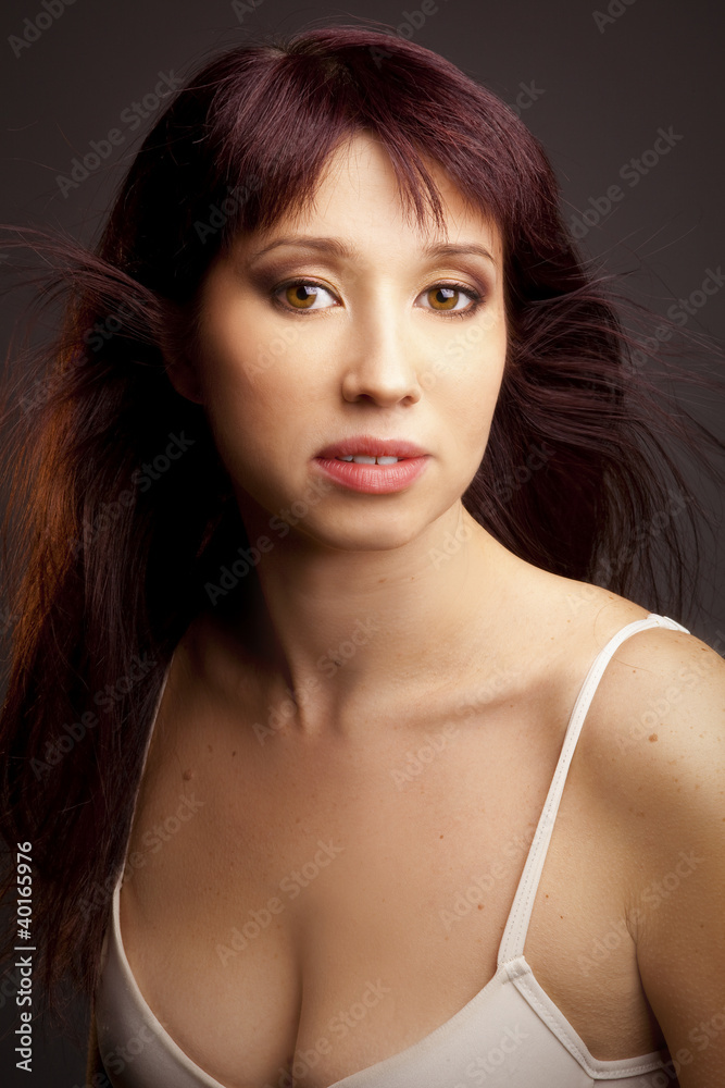 young woman luxurious brown hair, deep cleavage posing in studio