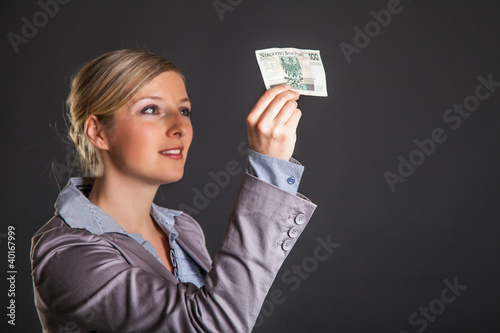 Woman with polish zloty money on dark gray background