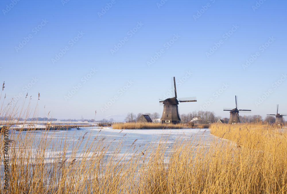 Windmill in winter time with snow and blue sky