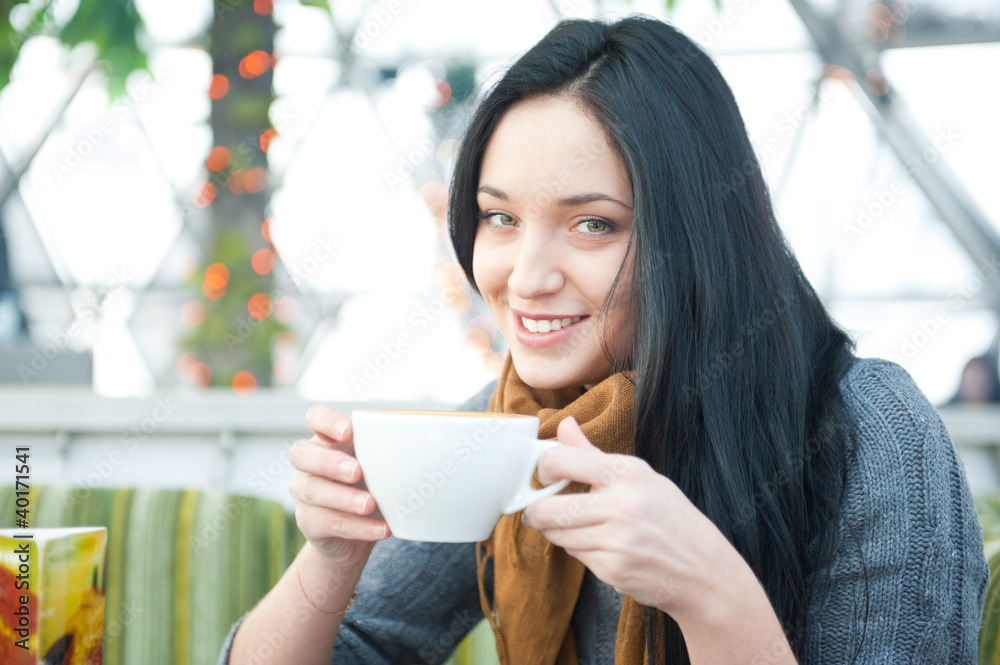 Pretty young female having a cup of coffee while resting at cafe Pretty young female having a cup of coffee while resting at cafe