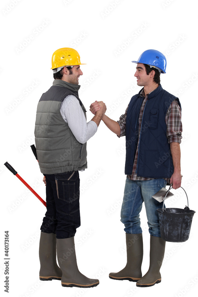 Two construction workers greeting each other