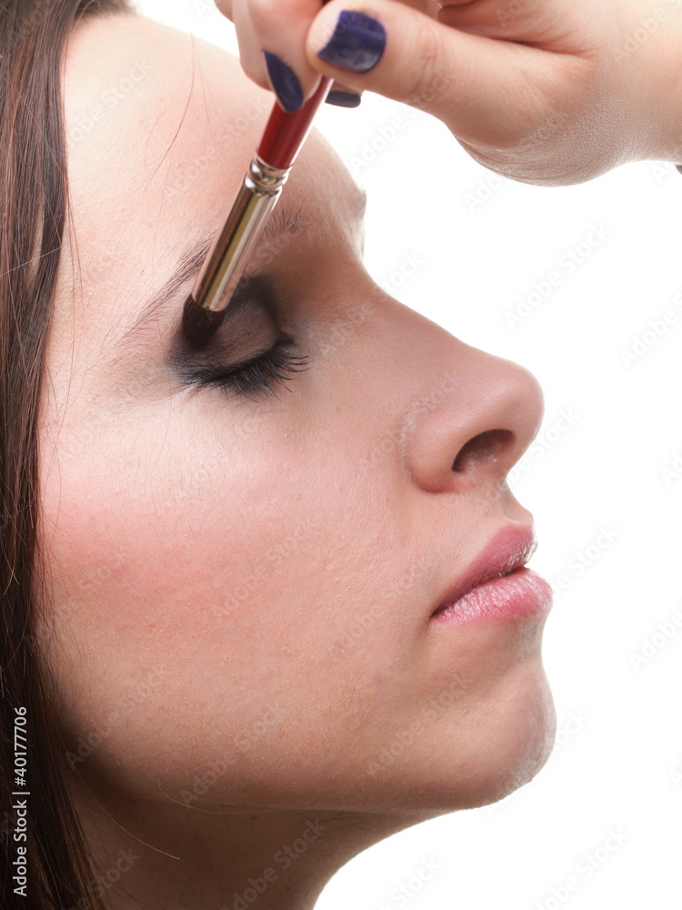 Woman applying eyeshadow makeup brush