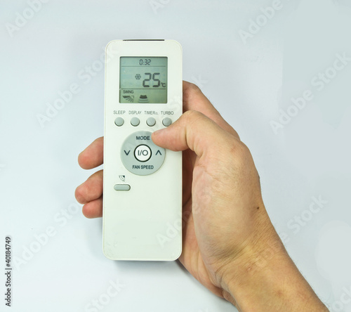 Hand is holding a remote control of air conditioner isolated