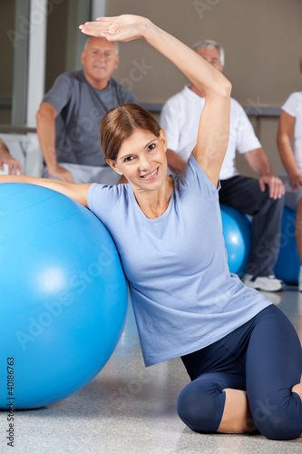 Frau macht Rückenübung mit Gymnastikball