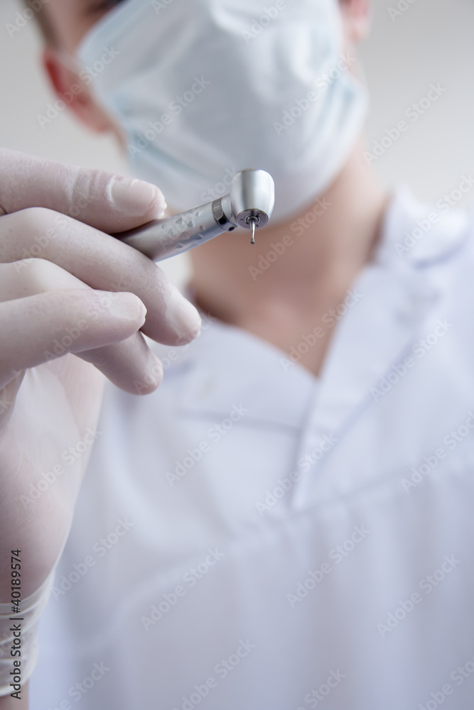 Hands of dentist holding dril. Hands of dentist holding dril.