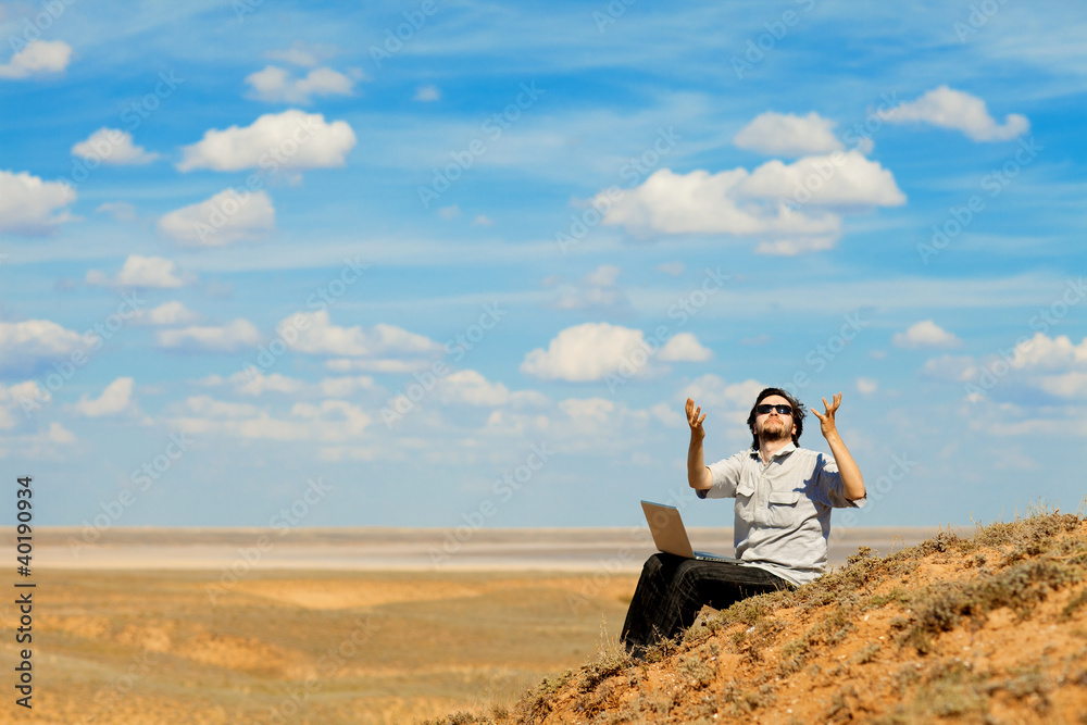 man with laptop praying to the God