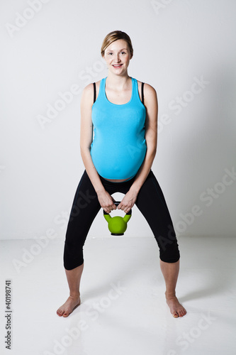 Pregnant woman exercising with kettlebell