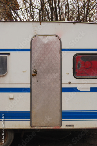 Old grungy aged caravan with metal door