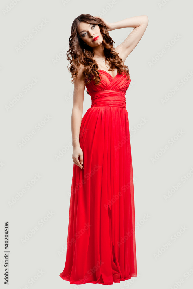 Beautiful female fashion model posing in red dress