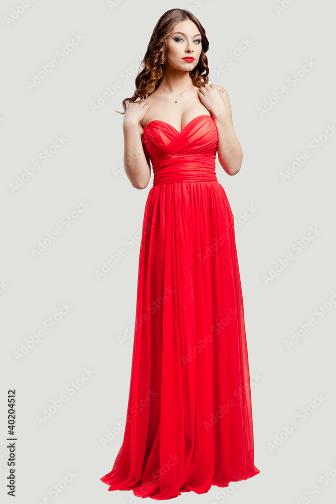 Beautiful female fashion model posing in red dress