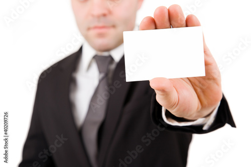 Businessman in black suit offering card, isolated over white bac