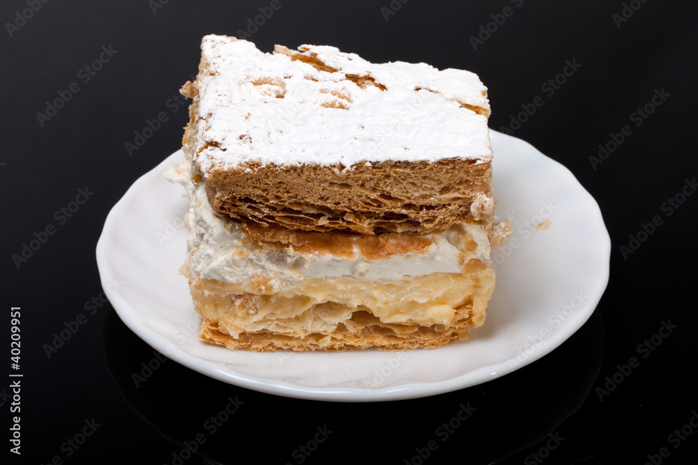 sweet  cake with cream isolated on black