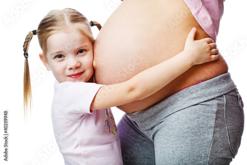 Beautiful pregnant woman with her daughter. Isolated on white
