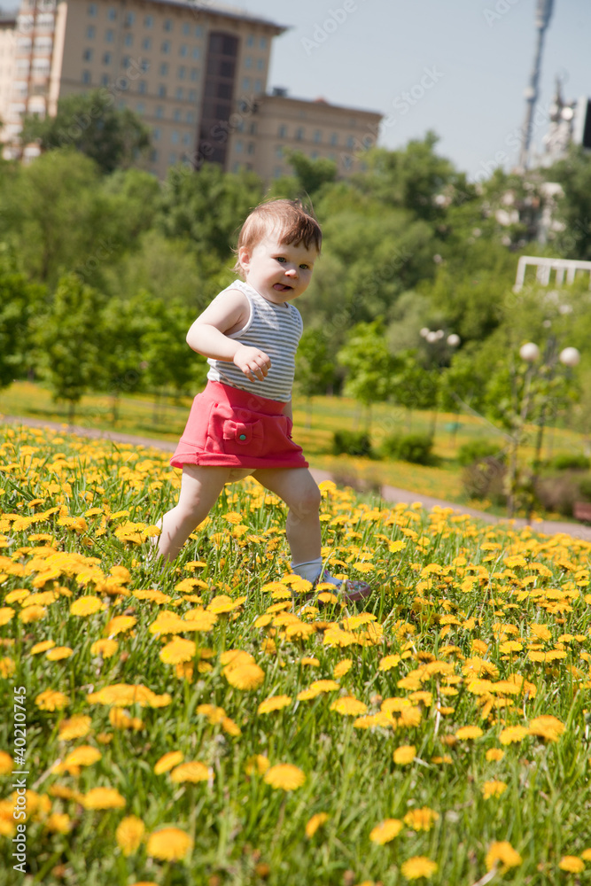 little girl runs on a meadow with dandelions little girl runs on a meadow with dandelions
