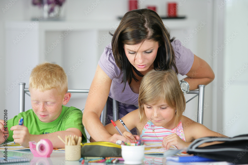 mother helping her kids with the homework mother helping her kids with the homework