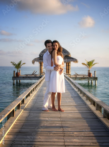 Sensual happy couple in white clothes on a pier (Maldives)