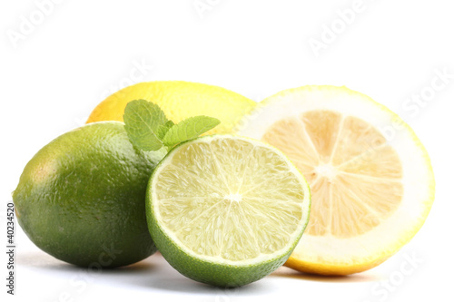 Fresh citrus fruits with mint leaves, whole and sliced limes and lemons, healthy refreshing ingredients